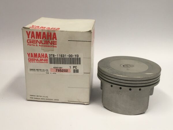 On a smooth surface, the Yamaha STD piston with part number 3TB-11631-00-Y0 is placed next to its box.
