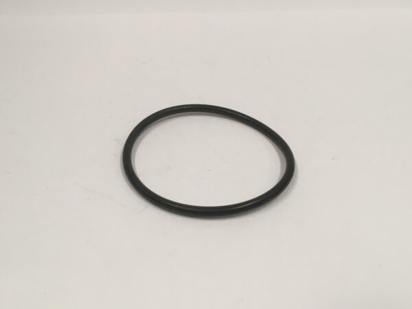 Una tapa de culata ovalada hecha de goma negra, similar a un sello tórico, se encuentra sobre un fondo blanco liso.