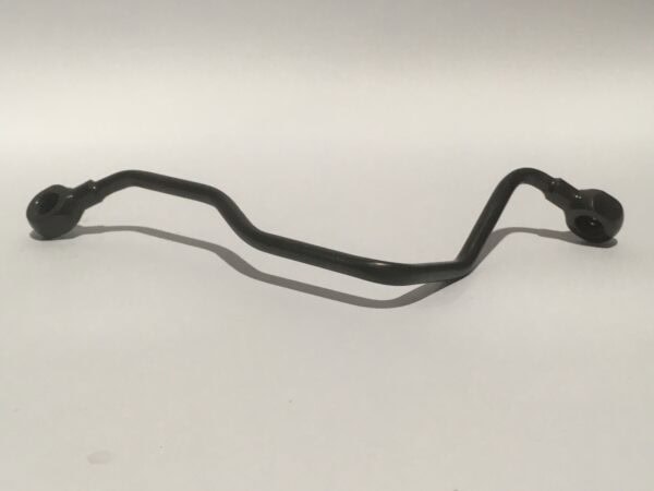 Un "Conducto engrasador culata" negro, con una varilla de metal doblada y extremos circulares, se muestra de manera elegante sobre un fondo claro y sencillo.