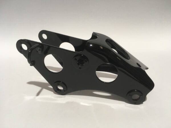 The Engine Frame Support is a black metal bracket with several circular cuts and mounting holes, ideal for engine applications. It is presented on a plain white background.