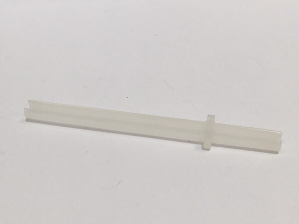 A small rear brake spring made of transparent plastic, with a flat edge and a cross shape in the center, is positioned on a pure white background.