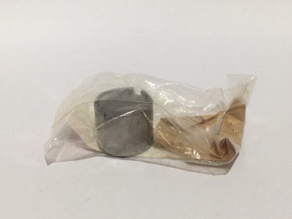 An elegant small cylinder shaped like a pill container is wrapped in transparent plastic and placed on an immaculate white surface.